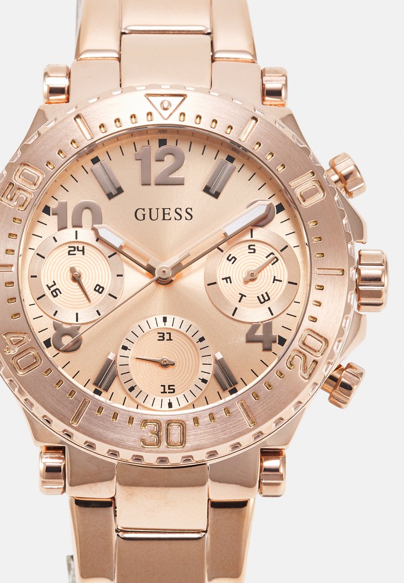 Montre chronographe en or rose avec trois sous-cadrans, cadran texturé et index lumineux. Dotée d'un bracelet en acier inoxydable.