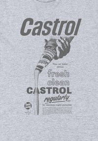 Grå t-shirt med et vintage Castrol reklame. Inkluderer fed tekst og en hånd, der hælder motorolie fra en dåse, som fremhæver olie-flow.