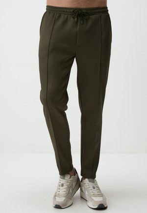 Pantalons de jogging vert olive en tissu texturé, dotés d'une taille élastique avec cordon de serrage, de poches latérales et de jambes fuselées.