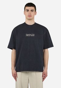 Tricou oversized din bumbac negru, cu decolteu rotund, având brodat pe piept logo-ul "Peachy Club Scent of Summer". Țesătură texturată.