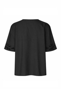 Czarny bawełniany top z krótkimi rękawami, ozdobiony haftowanymi wycięciami w kształcie liści na mankietach rękawów. Prosty, pudełkowy fason.