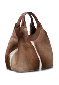 Borsa in pelliccia marrone con manici e dettagli in pelle, caratterizzata da una superficie testurizzata con macchie bianche. La forma curvata valorizza il design.