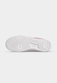 Σόλα αθλητικού παπουτσιού Nike, ορατή από κάτω, με κυκλικά σχέδια πέλματος και το λογότυπο Nike ανάγλυφο σε λευκή καουτσούκ.