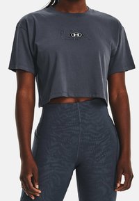 Avskuren mörkgrå t-shirt i bomull med korta ärmar, med broderad "UA"-logotyp och rund halsringning.