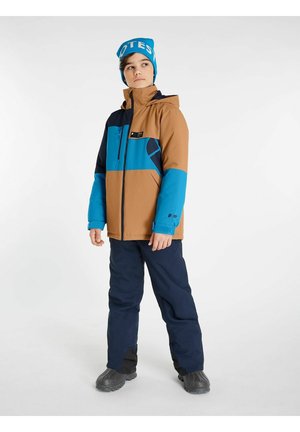 Veste colorée en blocs marron, bleue et noire avec une capuche ; bonnet bleu ; pantalon bleu marine ; matériau texturé. Bottes avec semelles en caoutchouc.