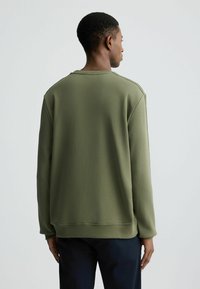 Felpa verde oliva con superficie testurizzata, collo a giro, maniche lunghe, con polsini e orlo a coste per un look aderente.