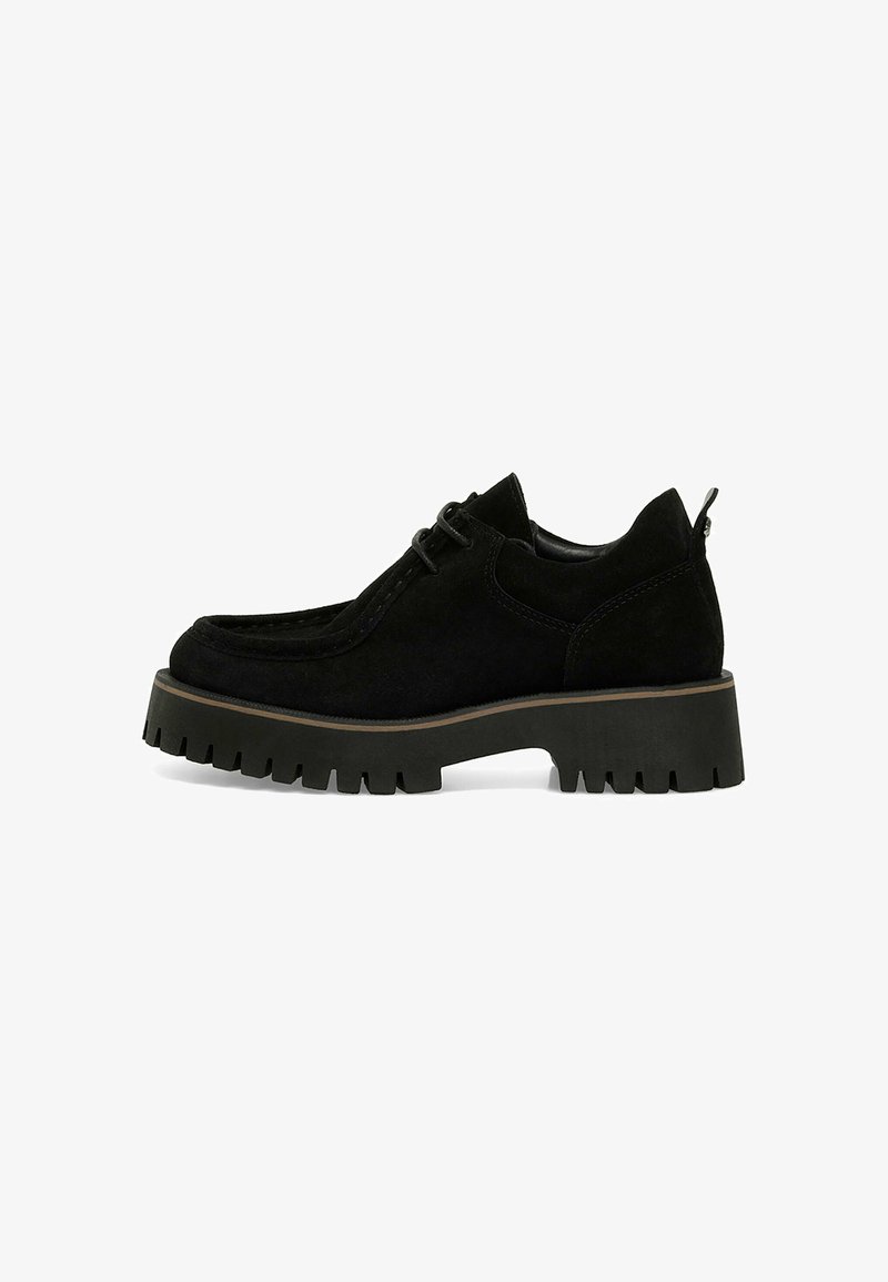 Scarpa in suede nero con design moccasin, punta rotonda e suola in gomma chunky caratterizzata da un battistrada spesso. Include dettagli cuciti e chiusura con lacci.
