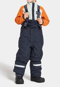 Marina snöbyxor med justerbara hängslen, reflexstripes och ett vattentätt tyg, i kombination med en jacka i fleece i orange och mint.