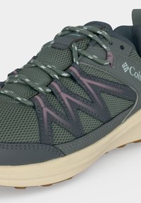 Γκρι και μοβ αθλητικό παπούτσι Columbia με ύφασμα mesh, κορδόνια με σχέδιο και μαλακό λευκό πέλμα, που δείχνει λεπτομέρειες από το πλάι και από πάνω.