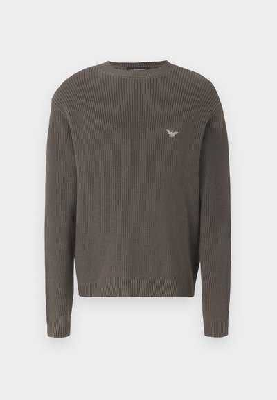 Temno zelena pletena majica z okroglim ovratnikom, rebrastimi manšetami in robom, z majhnim logotipom na prsih. Tekstura tkanine z oprijetim krojem.