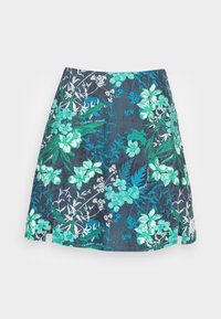 Mörkblå blommig kjol med gröna och vita blommor, något utsvängd med små sidoslitsar och en Tommy Jeans-etikett på fållen.