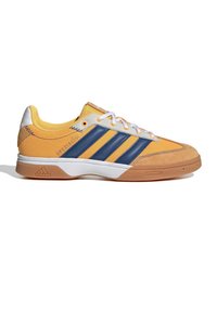 Chaussure de sport basse avec maille jaune et suède, rayures bleu marine, lacets blancs et semelle en caoutchouc naturel, vue de côté extérieur.