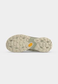 Semelle en caoutchouc beige d'une chaussure de randonnée avec des crampons profonds pour l'adhérence et un petit logo Vibram jaune au centre.
