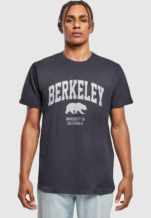 Mørk grå t-skjorte laget av bomull med "BERKELEY" og en bjørnegrafikk trykt i lys grå, med "UNIVERSITY OF CALIFORNIA" under.