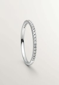 Anillo de plata con una banda delgada adornada con pequeños diamantes redondos y transparentes engastados en canal. Acabado liso y pulido en toda la pieza.