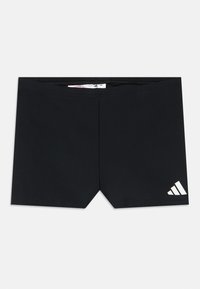 Mustad ujumispüksid, mille alumisel paremal jalal on väike valge Adidas logo, laotatud tasapinnale valgele taustale.