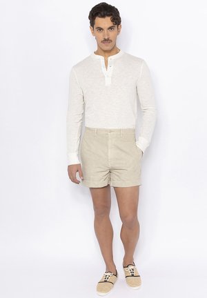 Witte lange mouwen henley shirt, beige linnen shorts, lichtgekleurde espadrilles. Gladde textuur, casual pasvorm, klassiek ontwerp.