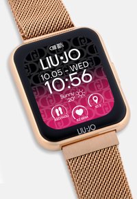 Rose-Gold-Smartwatch mit quadratischem Ziffernblatt, schwarzem Bildschirm, der Uhrzeit, Datum und Fitnessstatistiken anzeigt. Verfügt über ein Mesh-Armband und ein Logo.
