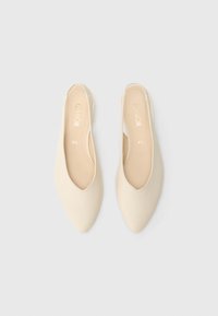 Beige Slingback-Schuhe mit spitzer Zehenpartie, glatter Textur und offenem Fersendesign. Verfügen über ein dezentes Markenlogo auf der Innensohle.