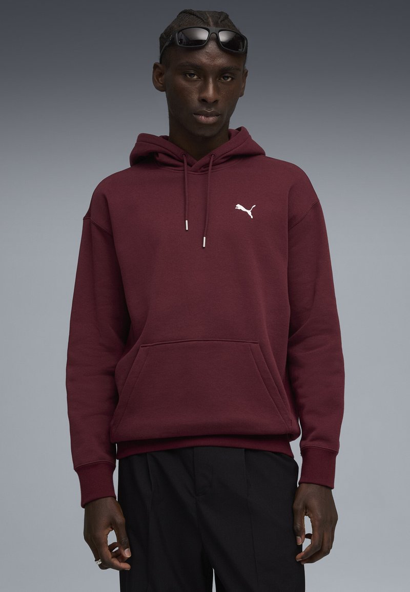 Bordeauxkleurige hoodie met een kangoeroezak, voorzien van een wit Puma-logo op de borst. Gestructureerde stof en ribgebreide manchetten.