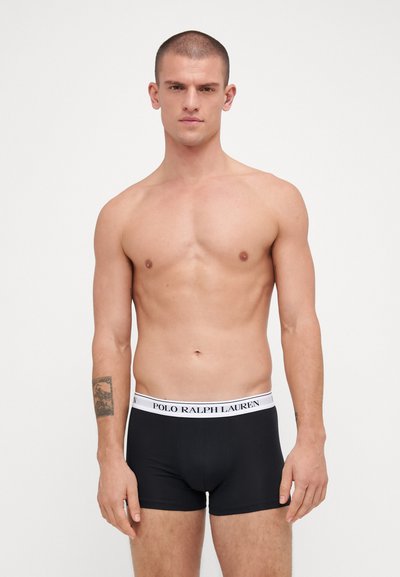 Caleçons boxers noirs avec une ceinture élastique blanche arborant le logo "POLO RALPH LAUREN". Le tissu semble lisse et ajusté.