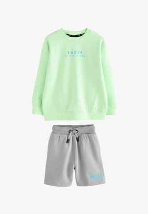 Svijetlozeleni dukserica s plavim logotipom "BAKER"; uparen sivoj kratkim hlačama s istim logotipom. Oboje izrađeno od mekog, udobnog materijala.
