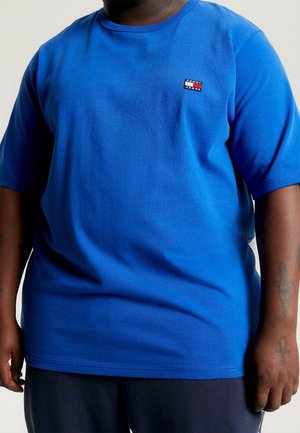Blå bomulds T-shirt med korte ærmer, rund halsudskæring og lille Tommy Jeans-logo i rød, hvid og blå på venstre bryst.