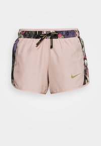 Light pink Nike shorts with a floral print waistband, elastic drawstring, and a small green logo on the front. Soft fabric, relaxed fit.