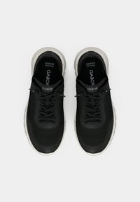 Chaussures de sport noires avec tige en mesh, fermeture à lacets et semelle coussinée. Dotées du logo Gabor et de la technologie FlexFlex pour le confort.