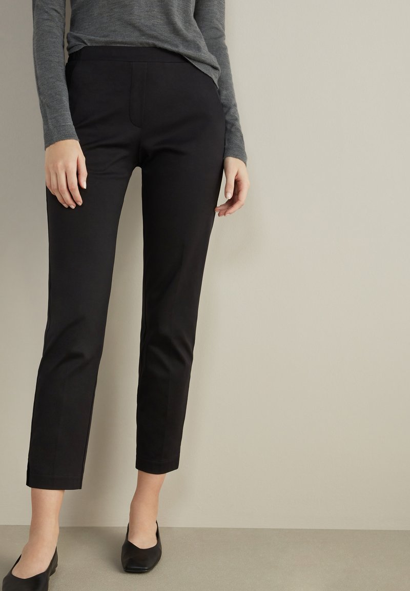 Svart skräddarsydda byxor med slim fit, med en slät textur, medelhög midja och subtila sömmar fram.