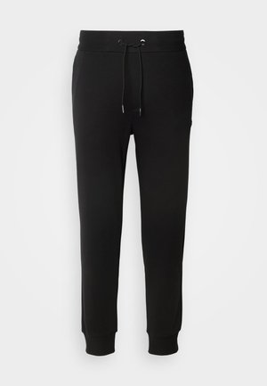 Pantalons de jogging en coton noir avec une taille élastique, cordon de serrage réglable, coupe fuselée et poignets côtelés. Pas de motifs ni d'accents visibles.
