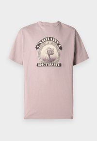 Svetlo roza bombažna majica z okroglim izrezom in kratkimi rokavi, ki ima grafični dizajn v vintage slogu z napisom "Carhartt WIP Detroit."