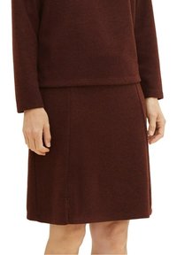 Bordový pletený šaty s kulatým výstřihem, dlouhými rukávy a rovnou siluetou. Má strukturovanou tkaninu a bezešvý design.