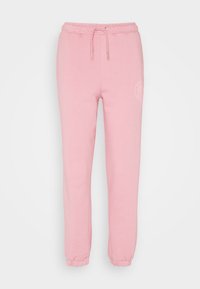 Pantalones de chándal rosa con una cintura elástica y cordón ajustable, que presentan puños ajustados en los tobillos y un sutil detalle de logo.