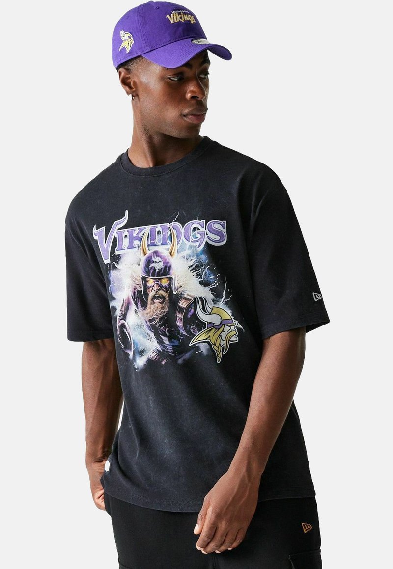 Schwarzes Grafik-T-Shirt mit einem Wikinger-Charakter, lila Akzenten und dem Text "Vikings". Kombiniert mit einer lila Kappe, die das Teamlogo zeigt.