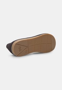 Sole de încălțăminte textilă neagră cu un fund din cauciuc maro texturat, având un grip cu model și un logo embosat. Design cu profil redus.