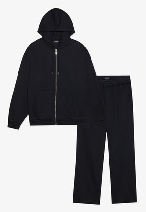 Black hoodie with zip closure and front pockets, paired with matching sweatpants featuring an elastic waistband and seam details.