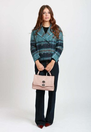Cappotto doppiopetto in misto lana turchese e blu navy con righe orizzontali, abbinato a una borsa in pelle rosa pallido con chiusura a clasp.