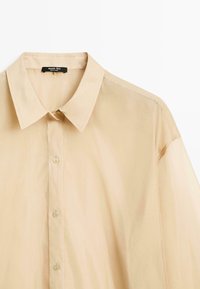 Beige overhemd met knoopsluiting en klassieke kraag, gemaakt van lichtgewicht stof. Kenmerkt zich door vijf knopen, nette naden en een lichtdoorzichtige textuur.