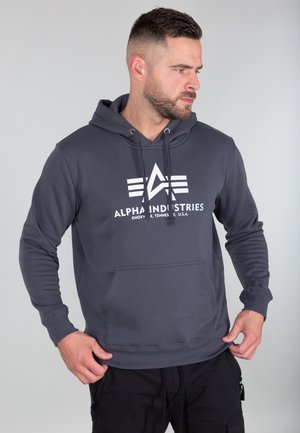 Gray hoodie with a front kangaroo pocket, adjustable drawstrings, and a white logo featuring geometric designs on the chest. Smooth fabric texture.