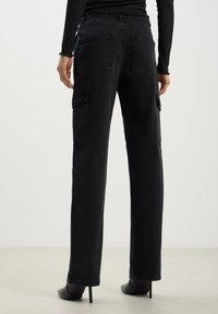 Pantaloni cargo in denim nero con gamba dritta, dotati di due tasche laterali e due tasche posteriori, tessuto testurizzato e vita di altezza media.