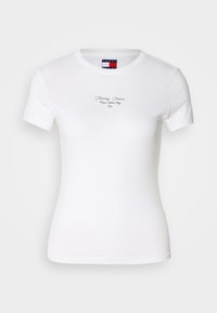 T-shirt bianca in cotone con maniche corte, colletto rotondo e testo ricamato "Tommy Jeans New York City" sul petto. Texture liscia.