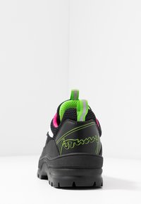 Scarpa sportiva nera realizzata in materiali mesh e sintetici, con dettagli in rosa e verde, dotata di una suola testurizzata e dettaglio del logo.