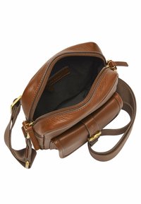 Sac à main en cuir marron avec une fermeture à glissière et une sangle ajustable. Il présente une finition texturée et une poche avant avec des accents en laiton.