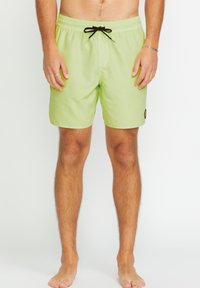 Costumi da bagno verde chiaro con cintura elastica, lacci neri e tasca laterale. Texture liscia con un'etichetta con logo sulla gamba sinistra.
