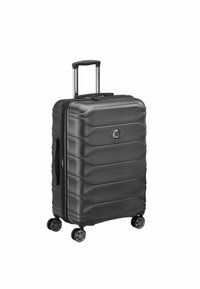 Black hard-shell suitcase with embossed horizontal stripes, dual wheels, retractable handle, and a zippered opening. Compact and sturdy design.