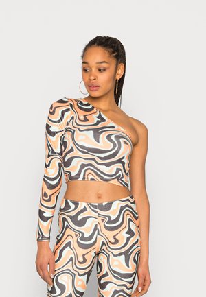 Top cropped de um ombro só com padrões ondulados abstratos em pêssego, preto e menta; ajustado com tecido elástico e leggings complementares.