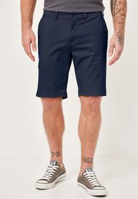 Marineblaue Shorts aus leichtem Material, mit glatter Textur und tailliertem Schnitt. Ausgestattet mit Taschen und gesäumten Säumen.
