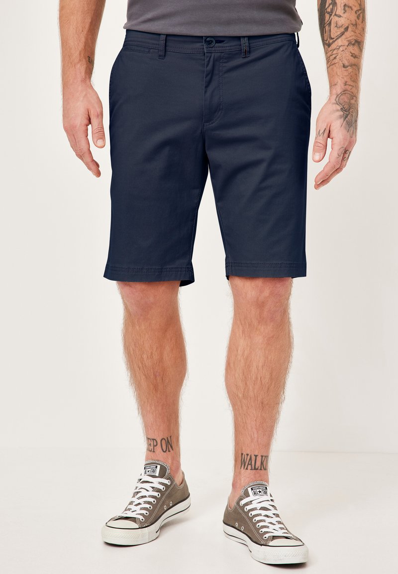 Marineblaue Shorts aus leichtem Material, mit glatter Textur und tailliertem Schnitt. Ausgestattet mit Taschen und gesäumten Säumen.