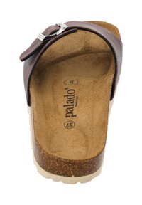 Sandalia deslizante de cuero marrón con un acento de hebilla plateada, plantilla similar a corcho, suela acolchada y superficie texturizada. Hecha en España.